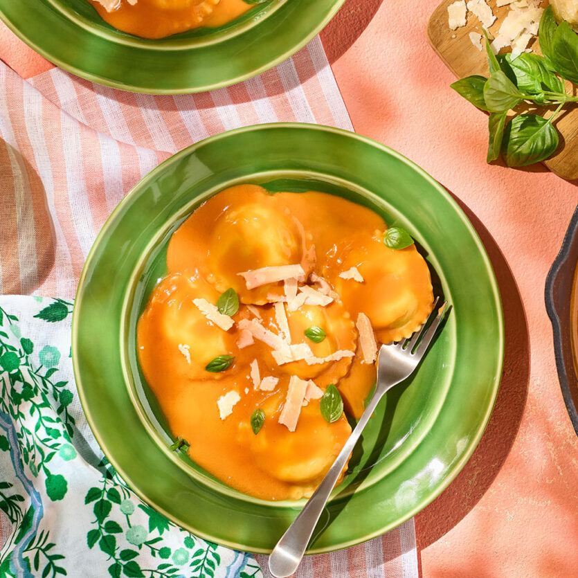 An image of prepared 3-Ingredient Creamy Tomato Basil Ravioli made with Pacific Foods™ Organic Vegan Creamy Tomato Basil Soup, cheese ravioli and Parmesan cheese.
