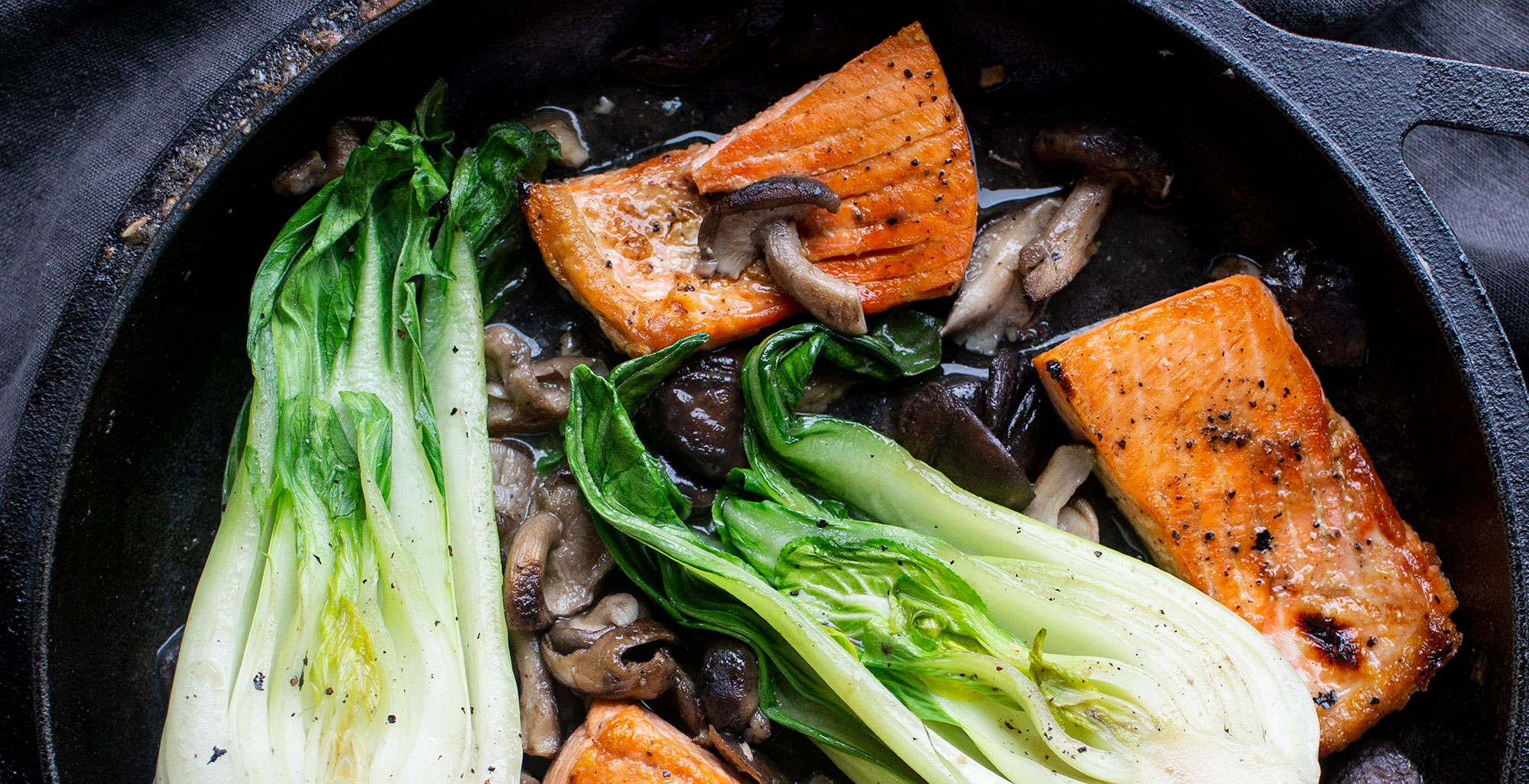 An image of prepared Asian Salmon with Shiitake Mushrooms and Baby Bok Choy made with mushrooms, Pacific Foods® Organic Mushrooms Broth, baby bok choy and wild salmon.