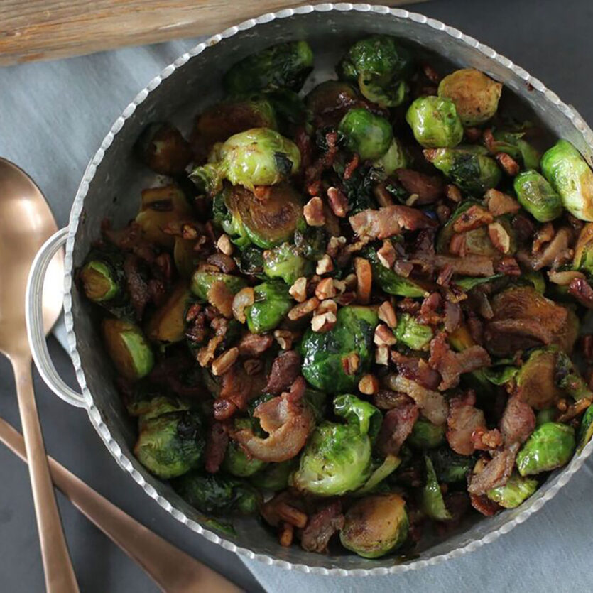 An image of prepared Bourbon Glazed Brussels Sprouts made with bacon, Brussels sprouts, Pacific Foods® Organic Chicken Stock, bourbon and pecans.