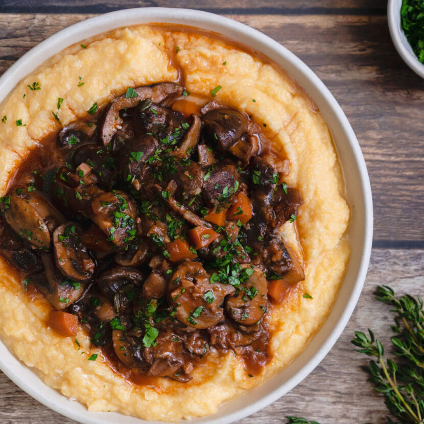 An image of prepared Braised Mushrooms with Polenta made with Pacific Foods® Organic Low Sodium Vegetable Broth, red wine, thyme, polenta and assorted mushrooms.