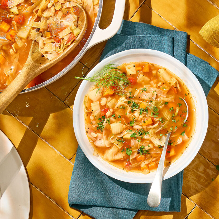 An image of prepared Cabbage and White Bean Soup made with carrot, fennel, garlic, green cabbage, tomatoes, Pacific Foods® Organic Unsalted Chicken Bone Broth, and white beans.