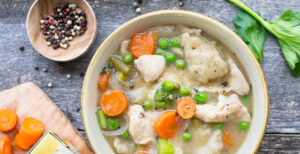 An image of prepared Classic Chicken and Dumplings made with chicken, carrots, onions, peas, Pacific Foods® Organic Cream of Chicken Soup, Pacific Foods® Organic Free Range Chicken Broth and milk.