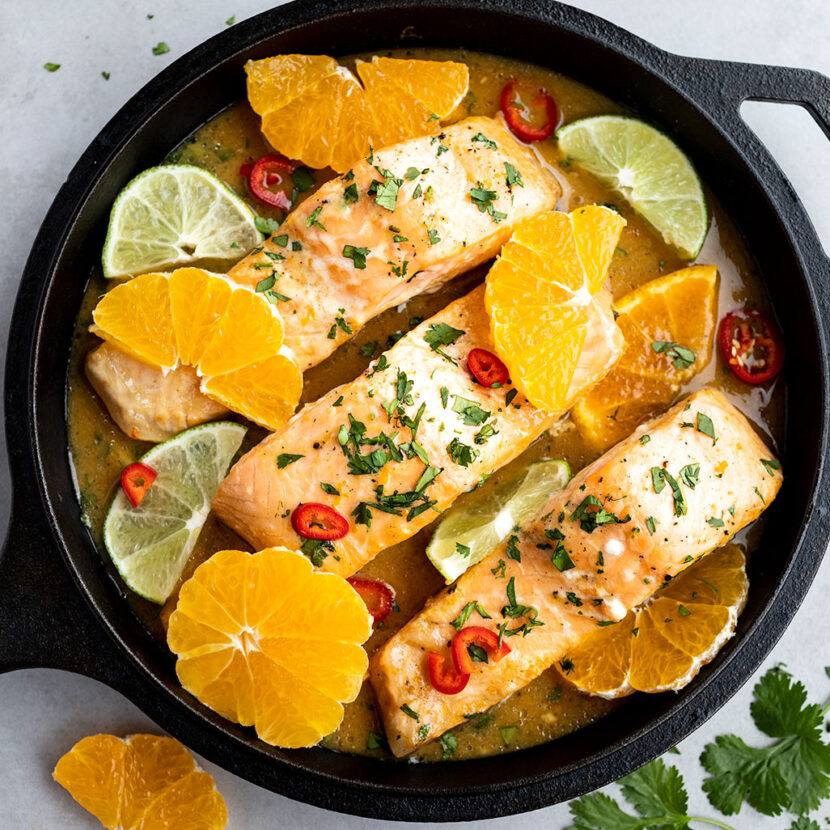 An image of prepared Coconut Citrus Poached Salmon made with oranges, limes, Pacific Foods® Organic Coconut Unsweetened Plant-Based Beverage, Pacific Foods® Organic Low Sodium Vegetable Broth, salmon and cilantro.