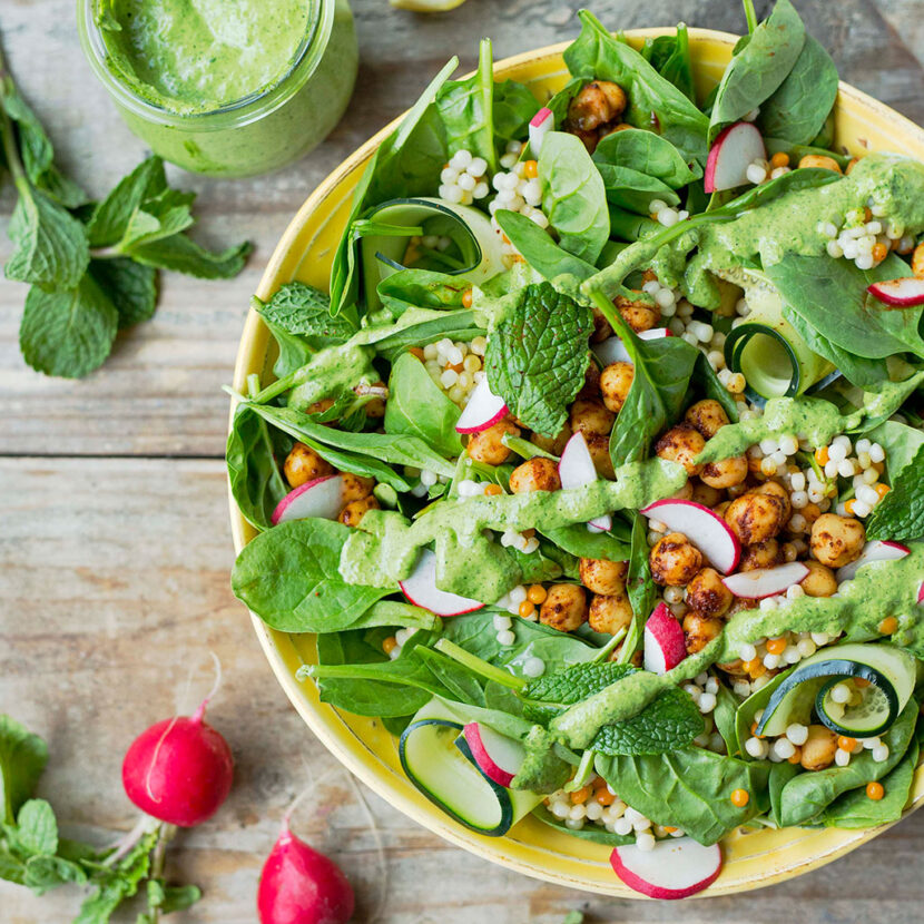 An image of prepared Couscous and Chickpea Salad made with cilantro, mint, parsley, Pacific Foods® Organic Coconut Original Beverage, spinach, cucumber, couscous and radish.