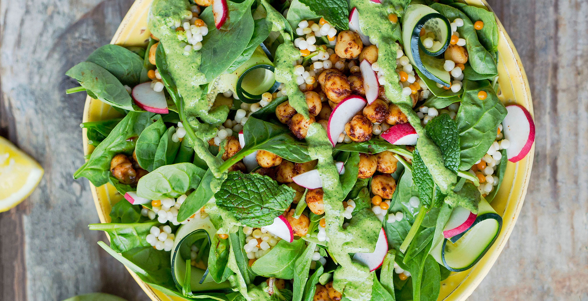 An image of prepared Couscous and Chickpea Salad made with cilantro, mint, parsley, Pacific Foods® Organic Coconut Original Beverage, spinach, cucumber, couscous and radish.