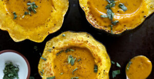 An image of prepared Winter Squash Soup made with pumpkin or acorn squash, butternut squash, sage, Pacific Foods® Organic Vegetable Broth and Pacific Foods® Organic Creamy Butternut Squash Soup.