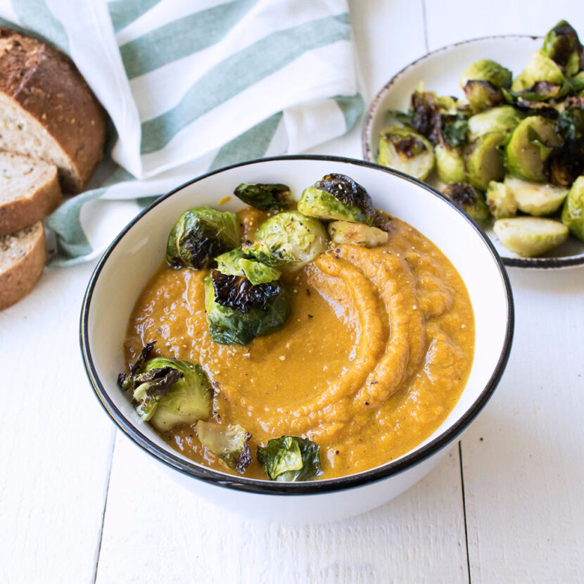 An image of prepared Creamy Pumpkin Soup with Crispy Brussels Sprouts made with Brussels sprouts, red onion, ginger, pumpkin, Pacific Foods® Organic Vegetable Broth and Pacific Foods® Organic Coconut Unsweetened Original Beverage.