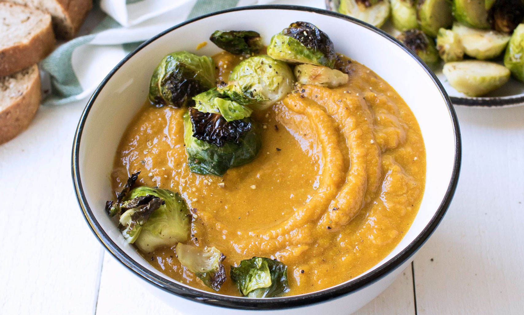 An image of prepared Creamy Pumpkin Soup with Crispy Brussels Sprouts made with Brussels sprouts, red onion, ginger, pumpkin, Pacific Foods® Organic Vegetable Broth and Pacific Foods® Organic Coconut Unsweetened Original Beverage.