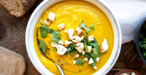 An image of prepared Creamy Carrot and White Bean Soup made with ginger, carrot, Pacific Foods® Organic Vegetable Broth, cannellini beans and cashews.