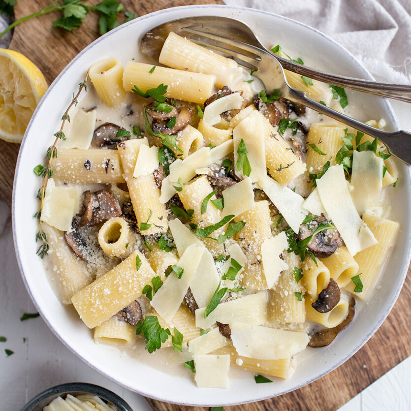 An image of prepared Creamy Gluten-Free Mushroom Pasta with Thyme and Garlic made with Pacific Foods® Organic Cream of Mushroom Condensed Soup, Pacific Foods® Mushroom Broth, Parmesan cheese, button mushrooms, gluten-free rigatoni pasta and lemon.
