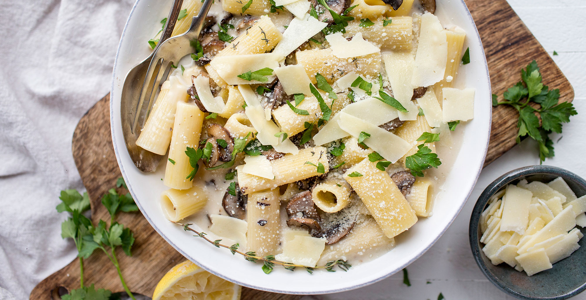 An image of prepared Creamy Gluten-Free Mushroom Pasta with Thyme and Garlic made with Pacific Foods® Organic Cream of Mushroom Condensed Soup, Pacific Foods® Mushroom Broth, Parmesan cheese, button mushrooms, gluten-free rigatoni pasta and lemon.