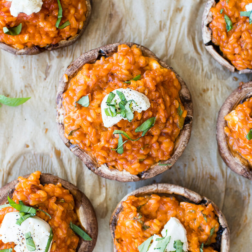 An image of Creamy Tomato Risotto Stuffed Mushrooms with Goat Cheese made with brown rice, Pacific Foods® Organic Free Range Chicken Broth, Pacific Foods™ Organic Creamy Tomato Soup, portobello mushrooms, goat cheese and basil.