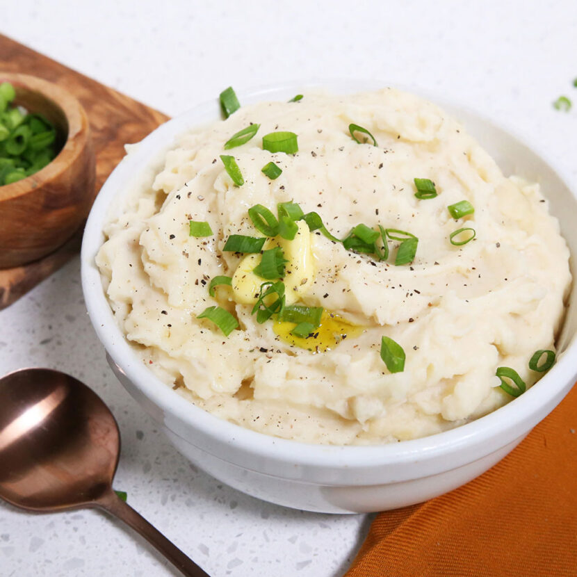 An image of prepared Crockpot Mashed Potatoes made with russet potatoes, Pacific Foods® Organic Turkey Broth, Pacific Foods® Organic Unsweetened Almond Original Beverage, butter and green onions.