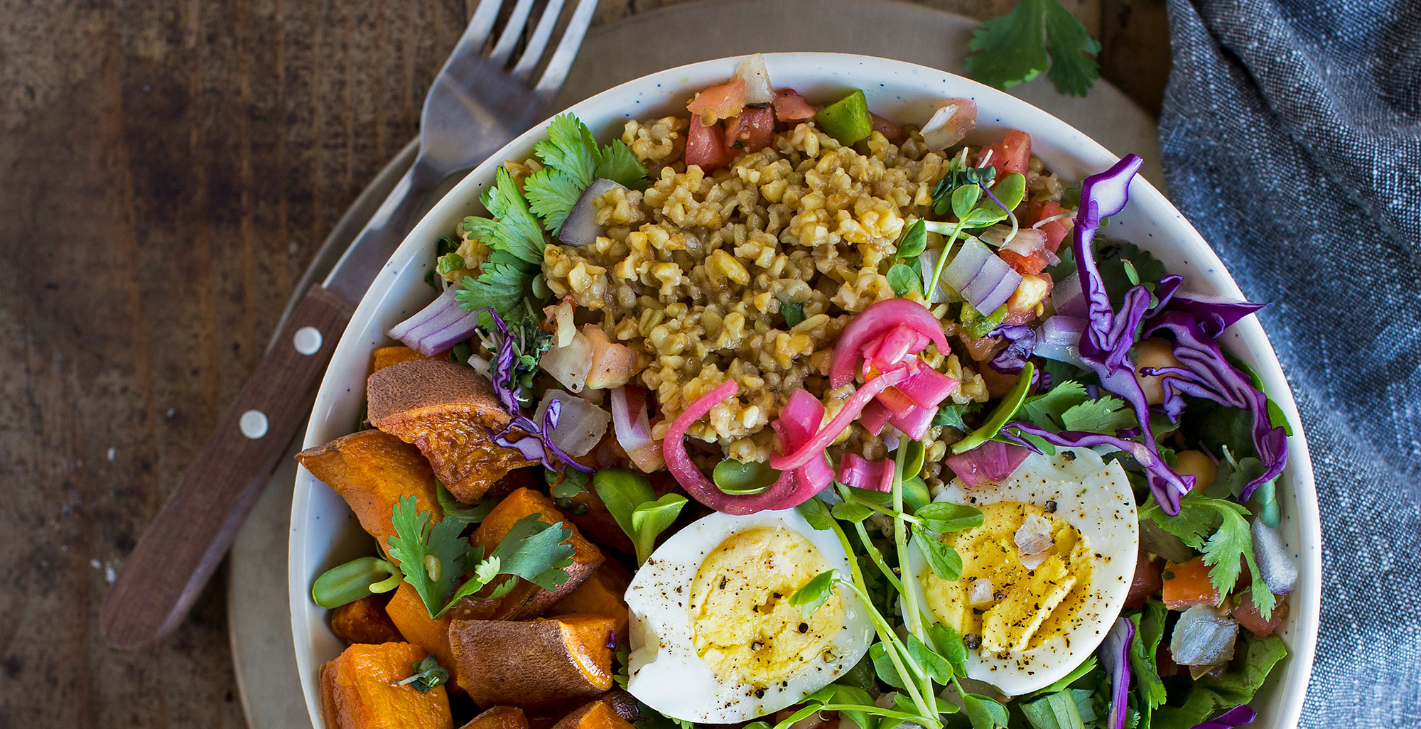 An image of prepared Farro and Roasted Vegetable Bone Broth Bowl made with Pacific Foods® Organic Chicken Bone Broth with Sea Salt, farro, sweet potato, baby arugula, red cabbage and hard cooked egg.