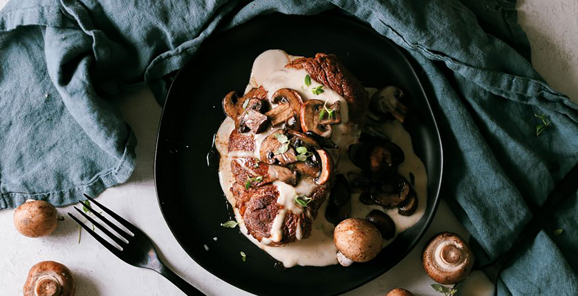 An image of prepared Filet Mignon With Mushroom Sauce made with shallot, Pacific Foods® Organic Mushroom Broth, cream, filet mignon and cremini mushrooms.