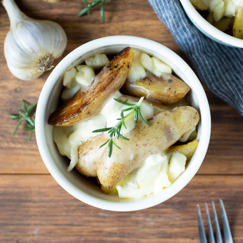 An image of prepared Fingerling Potato Poutine made with potatoes, garlic, rosemary, thyme, Pacific Foods® Organic Low Sodium Chicken Broth and cheese curds.