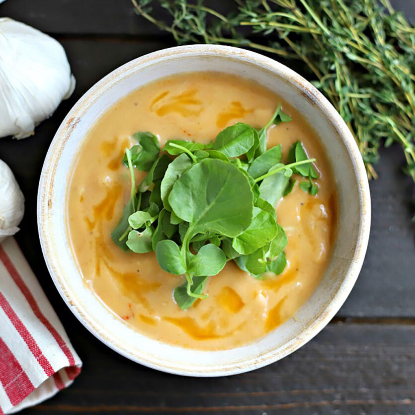 An image of prepared Garlic Soup with Beef Bone Broth made with garlic, thyme, onion, cauliflower, Pacific Foods® Organic Beef Bone Broth and watercress.
