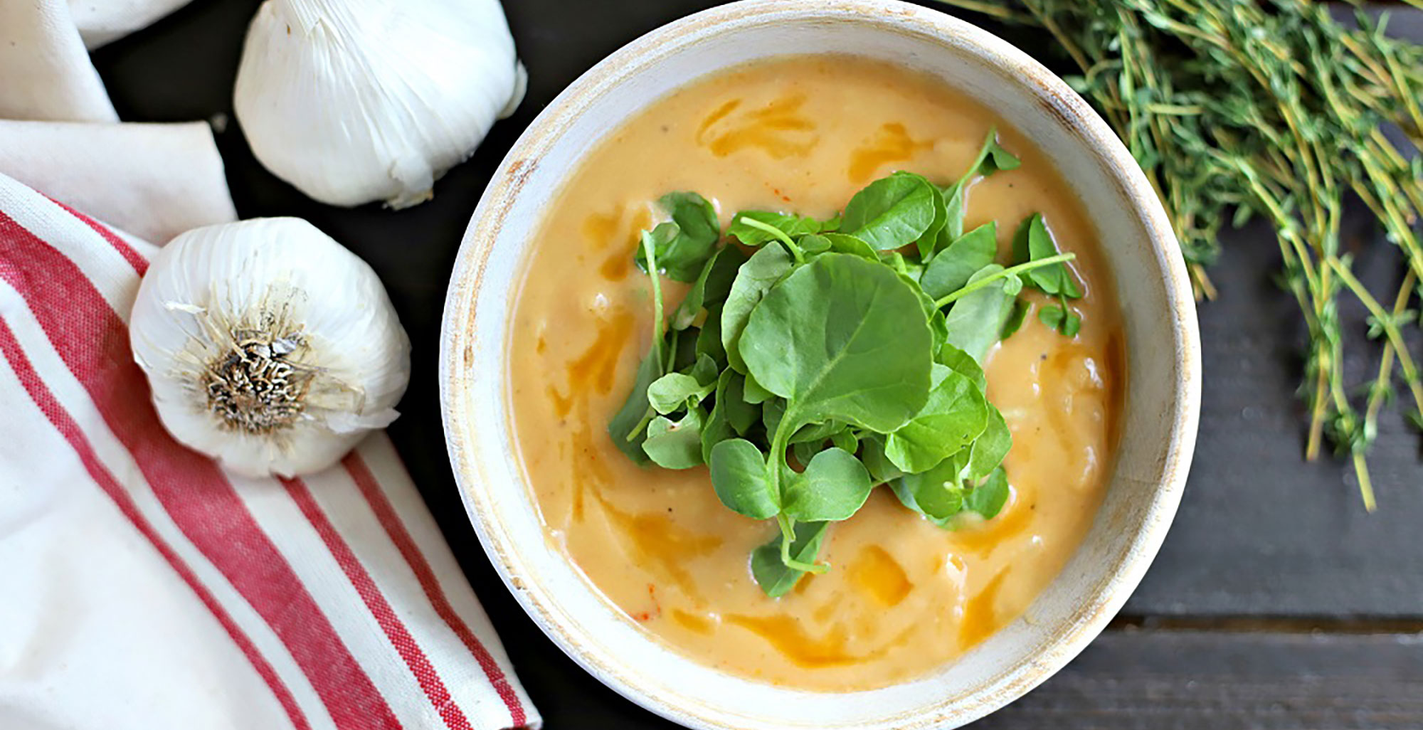 An image of prepared Garlic Soup with Beef Bone Broth made with garlic, thyme, onion, cauliflower, Pacific Foods® Organic Beef Bone Broth and watercress.