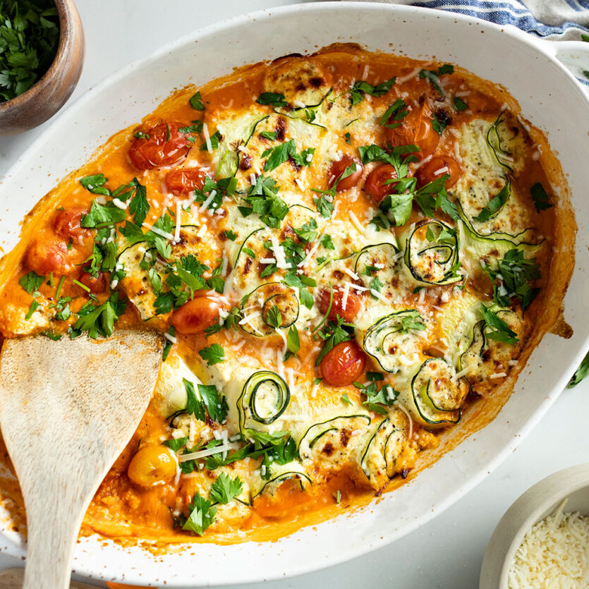 An image of prepared Gluten-Free Zucchini Lasagna Rollups made with zucchini, Pacific Foods® Organic Creamy Tomato Basil Soup, ricotta, mozzarella, Parmesan, cherry tomatoes and parsley.
