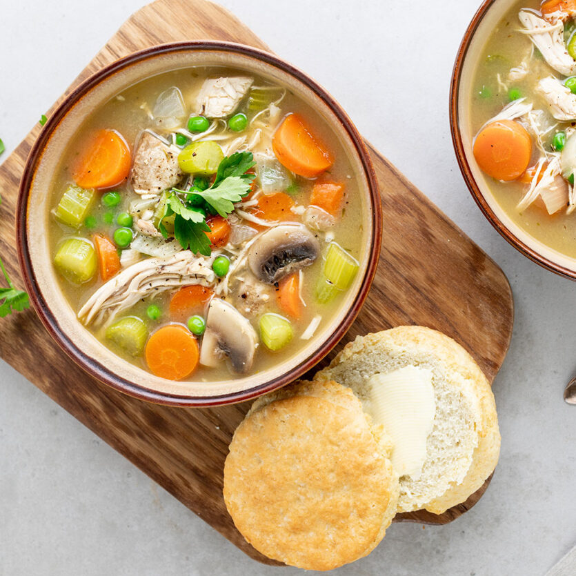 An image of prepared Instant Pot® Chicken Pot Pie Soup made with Pacific Foods® Organic Cream of Chicken Condensed Soup, Pacific Foods® Organic Free Range Chicken Broth, mushrooms, peas, chicken and biscuits.