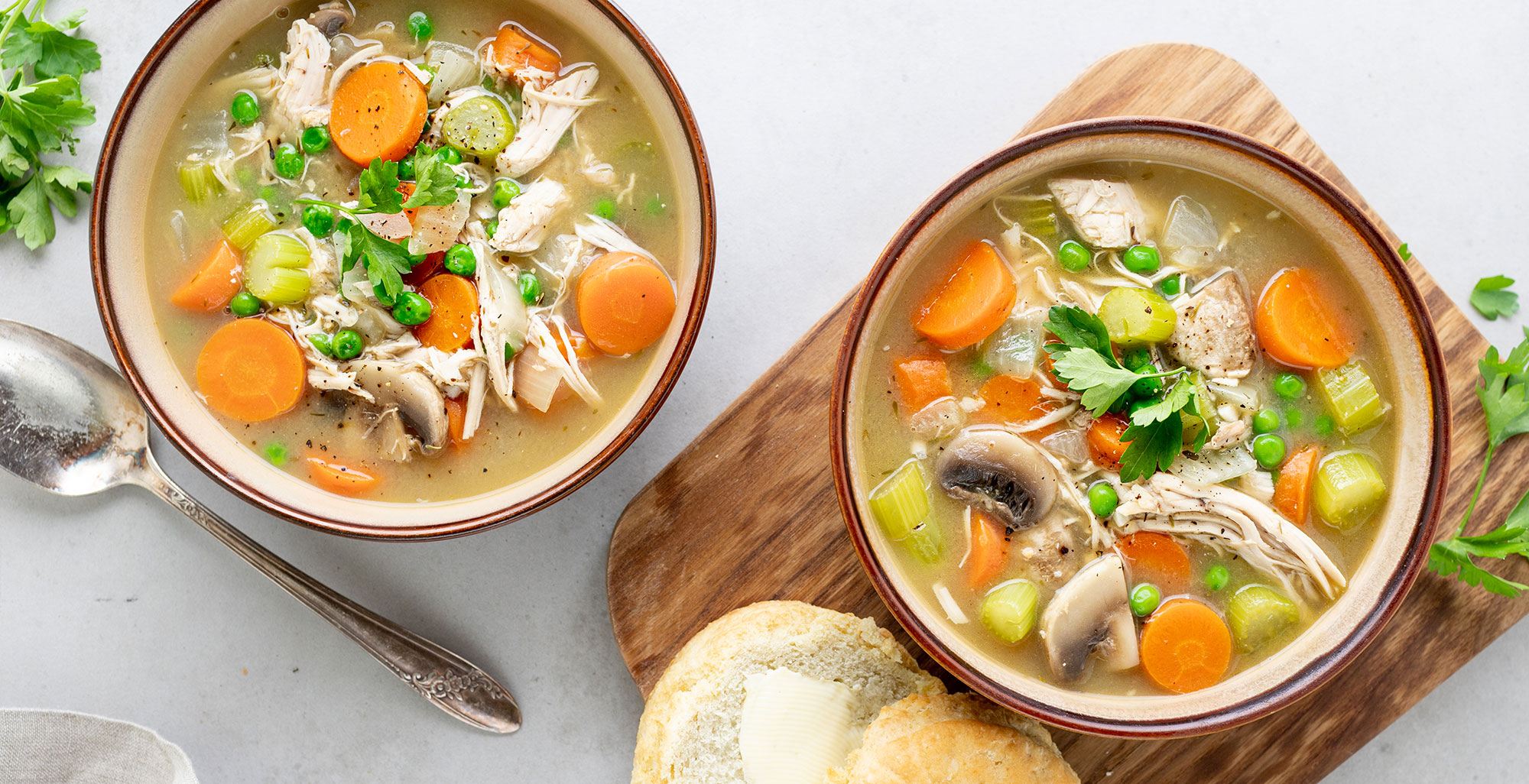 An image of prepared Instant Pot® Chicken Pot Pie Soup made with Pacific Foods® Organic Cream of Chicken Condensed Soup, Pacific Foods® Organic Free Range Chicken Broth, mushrooms, peas, chicken and biscuits.