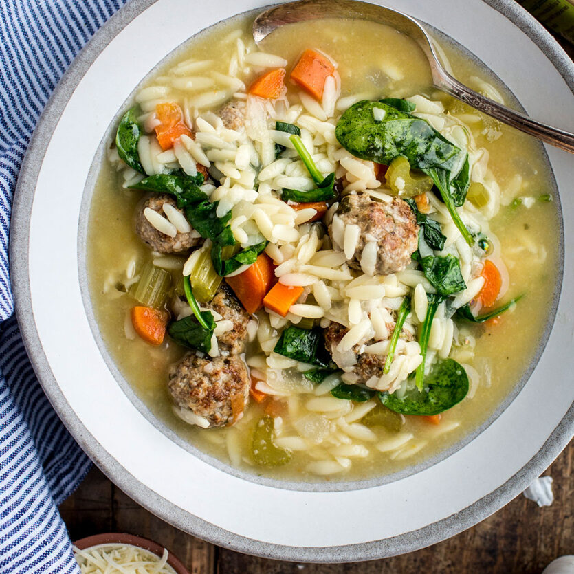 An image of prepared Italian Wedding Soup made with ground pork, ground beef, Parmesan, Pacific Foods® Organic Chicken Bone Broth with Sea Salt, spinach and orzo.