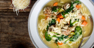 An image of prepared Italian Wedding Soup made with ground pork, ground beef, Parmesan, Pacific Foods® Organic Chicken Bone Broth with Sea Salt, spinach and orzo.