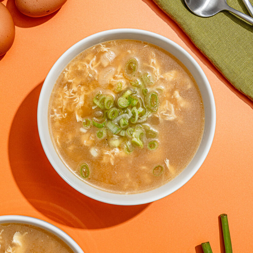 An image of prepared Keto Egg Drop Soup made with onion, Pacific Foods® Organic Unsalted Chicken Bone Broth, eggs and green onions.