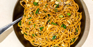 An image of prepared Kung Pao Noodles made with spaghetti, Pacific Foods® Organic Free Range Chicken Broth, peanuts and sesame seeds.