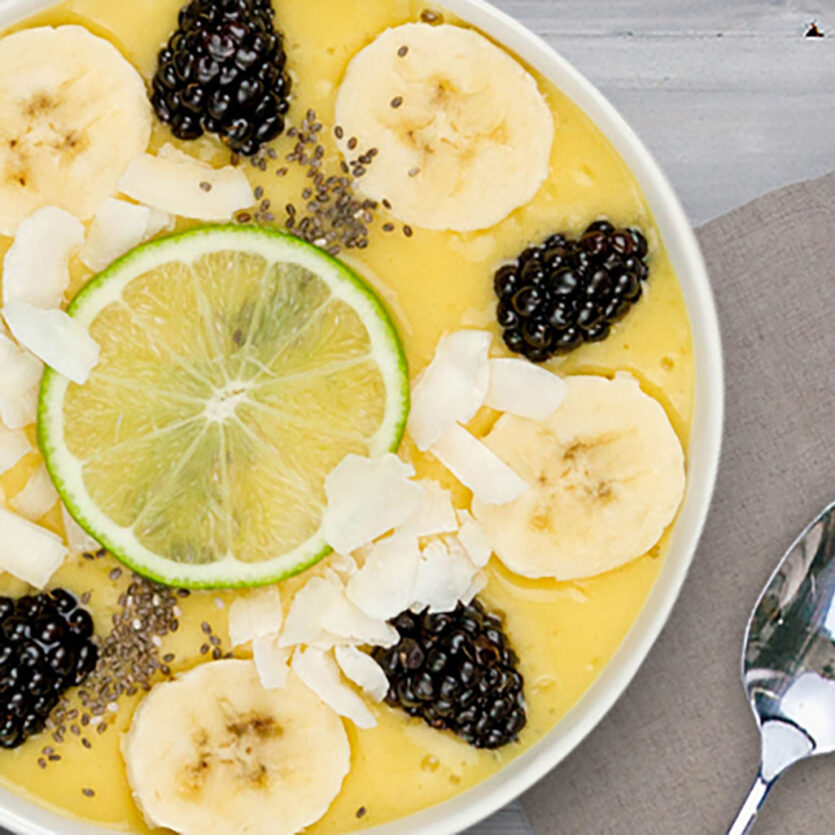 An image of prepared Mango Orange Banana Smoothie Bowl made with mango, banana, Pacific Foods® Organic Coconut Original Beverage, orange juice, blackberries, coconut and chia seeds.