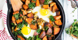 An image of prepared One-Skillet Sweet Potato and Kale Hash made with sweet potato, kale, Pacific Foods® Organic Chicken Bone Broth and eggs.