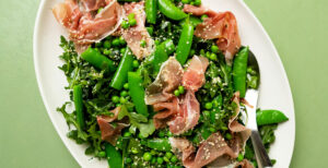 An image of prepared Pea, Arugula and Prosciutto Salad made with Pacific Foods® Organic Free Range Chicken Broth, snap peas, arugula, prosciutto and hemp seeds.
