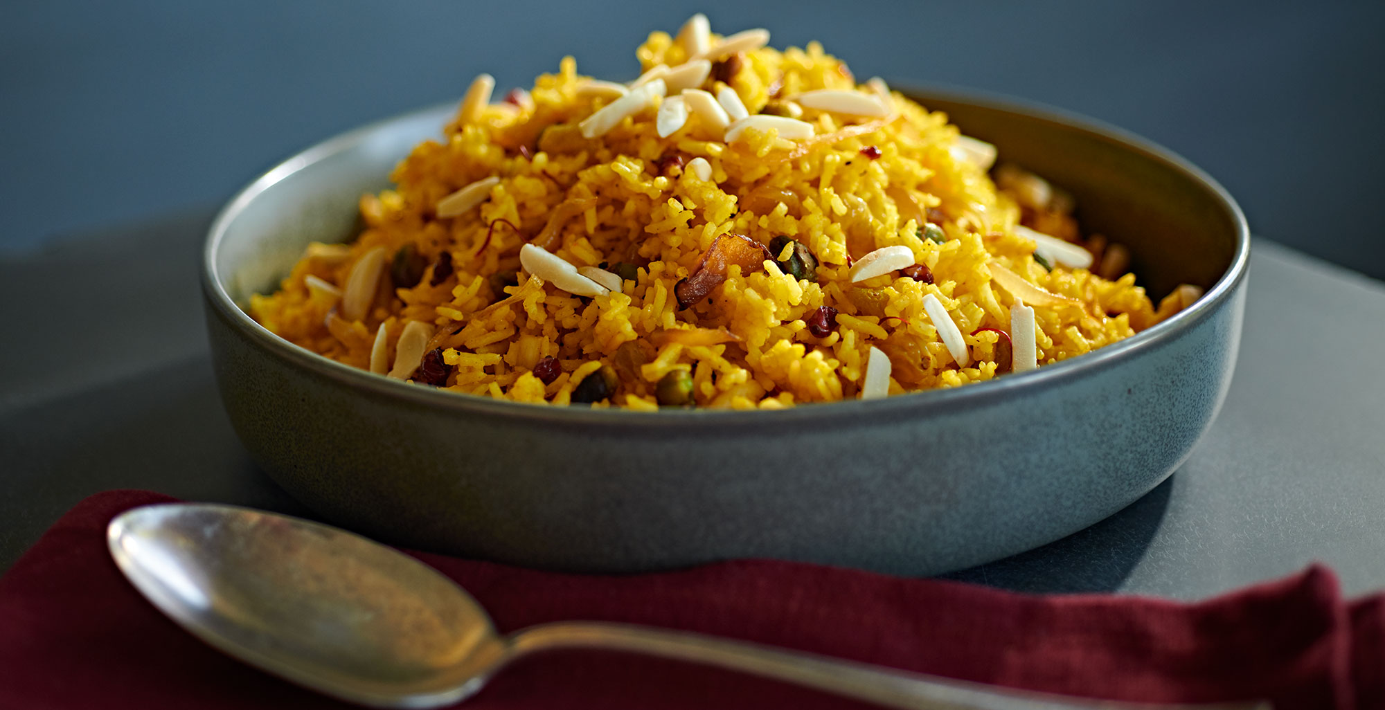 An image of prepared Persian Jeweled Rice made with onion, almonds, pistachios, basmati rice, barberries, Pacific Foods® Organic Vegetable Broth, Pacific Foods® Organic Cashew Ginger Soup and saffron.
