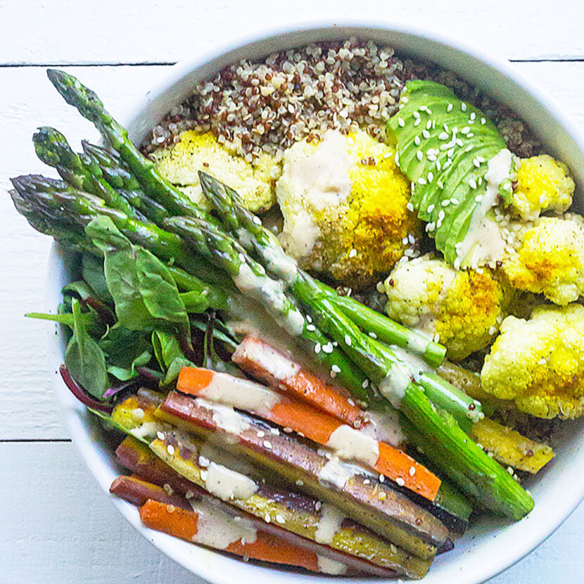 An image of prepared Roasted Cauliflower Bowls with Creamy Coconut Dressing made with asparagus, cauliflower, carrots, quinoa, turmeric, Pacific Foods® Organic Coconut Original Beverage, avocado and mixed greens.