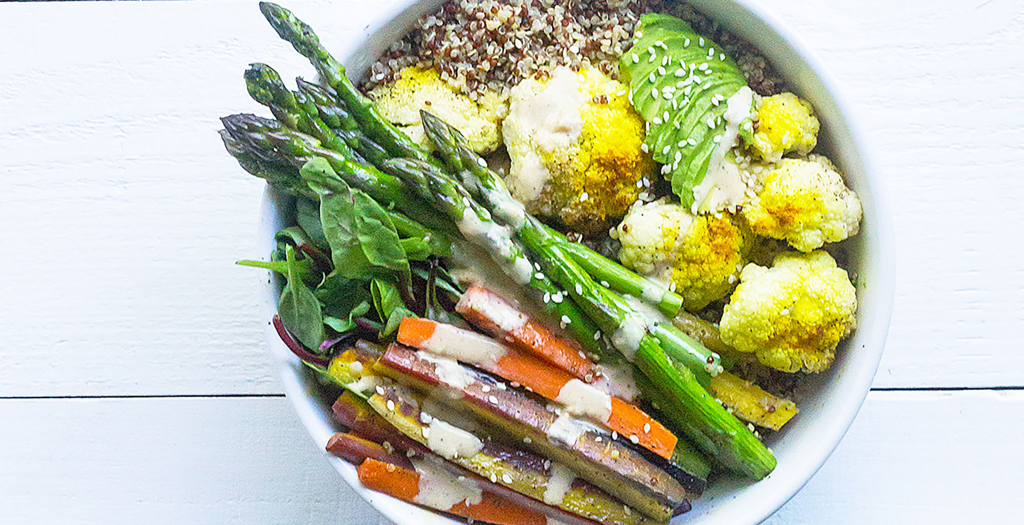 An image of prepared Roasted Cauliflower Bowls with Creamy Coconut Dressing made with asparagus, cauliflower, carrots, quinoa, turmeric, Pacific Foods® Organic Coconut Original Beverage, avocado and mixed greens.