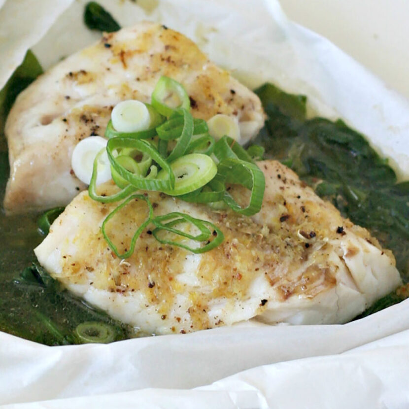 An image of prepared Sesame Cod en Papillote with Ginger and Scallions made with Pacific Foods® Organic Unsalted Chicken Stock, spinach and cod.