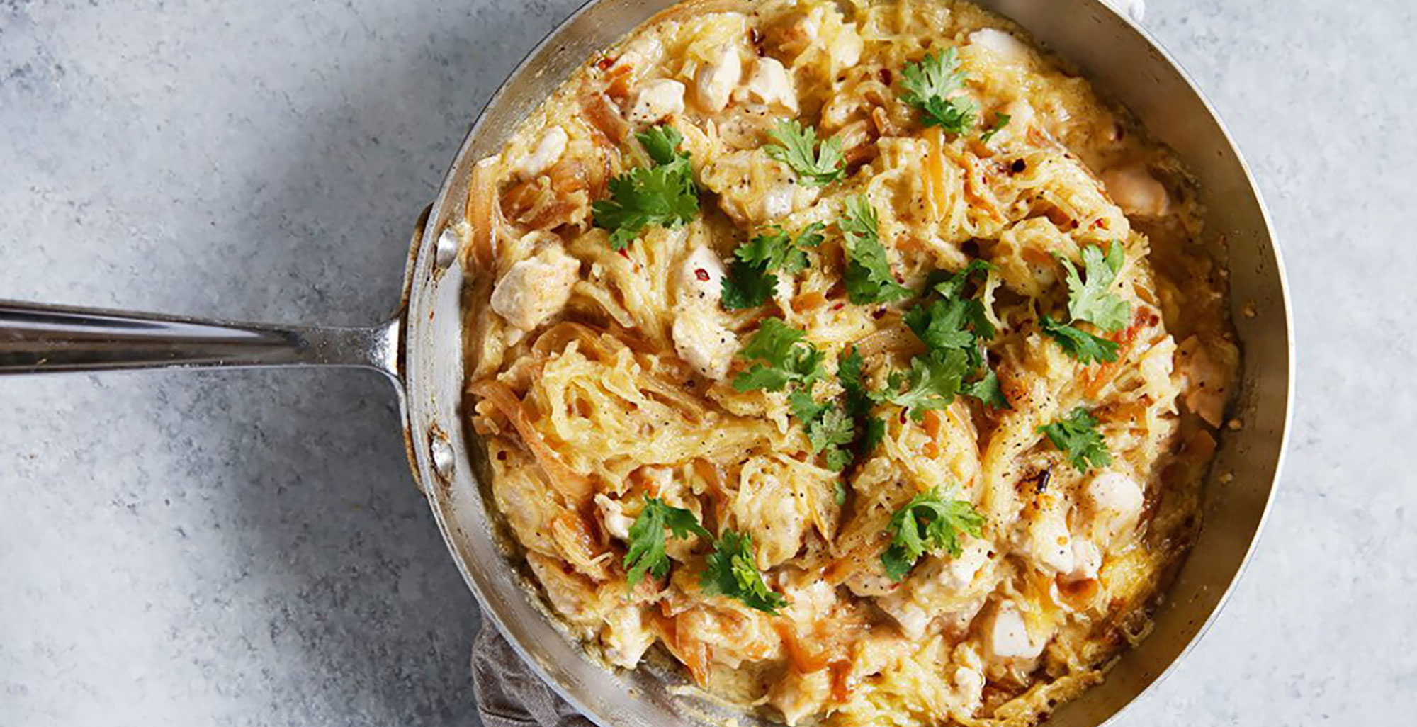 An image of prepared Spaghetti Squash Alfredo with Chicken and Caramelized Onions made with spaghetti squash, onion, chicken, mayonnaise, Pacific Foods® Organic Almond Original Beverage and Parmesan cheese.