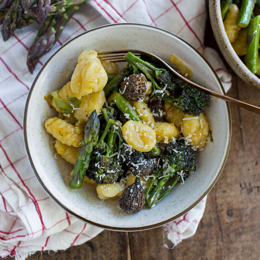 An image of prepared Spring Gnocchi with Morels and Asparagus made with potato gnocchi, leeks, mushrooms, brocolini, asparagus, Pacific Foods® Organic Vegetable Broth and Parmesan cheese.