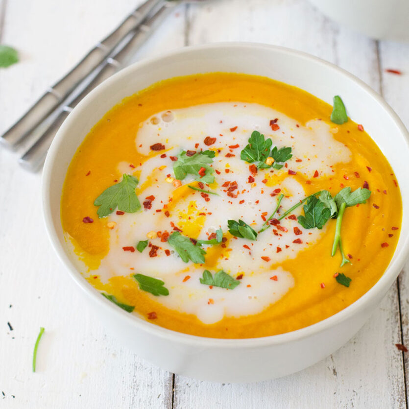 An image of prepared Thai Coconut Carrot Soup made with onion, carrot, Thai red curry paste, Pacific Foods® Organic Vegetable Broth, Pacific Foods® Organic Coconut Plant-Based Beverage, lime juice and cilantro.