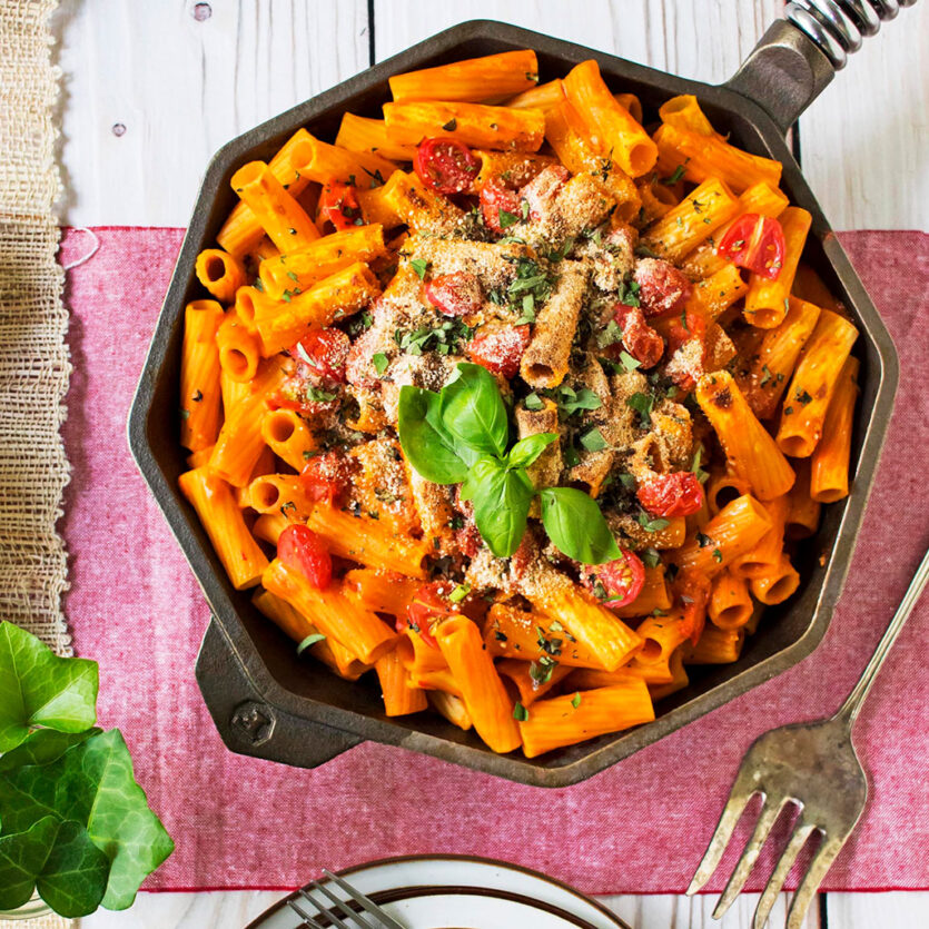 An image of prepared Vegan Rigatoni Bake made with rigatoni pasta, Pacific Foods® Organic Creamy Tomato Basil Soup, basil, oregano, cherry tomatoes and bread crumbs.