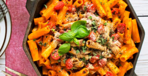 An image of prepared Easy Rigatoni Bake made with rigatoni pasta, Pacific Foods® Organic Creamy Tomato Basil Soup, basil, oregano, cherry tomatoes and bread crumbs.
