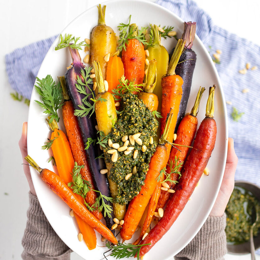 An image of prepared Whole Roasted Rainbow Carrots with Carrot Top Pesto made with carrots, Pacific Foods® Organic Vegetable Broth, garlic, pine nuts, basil, Parmesan and olive oil.