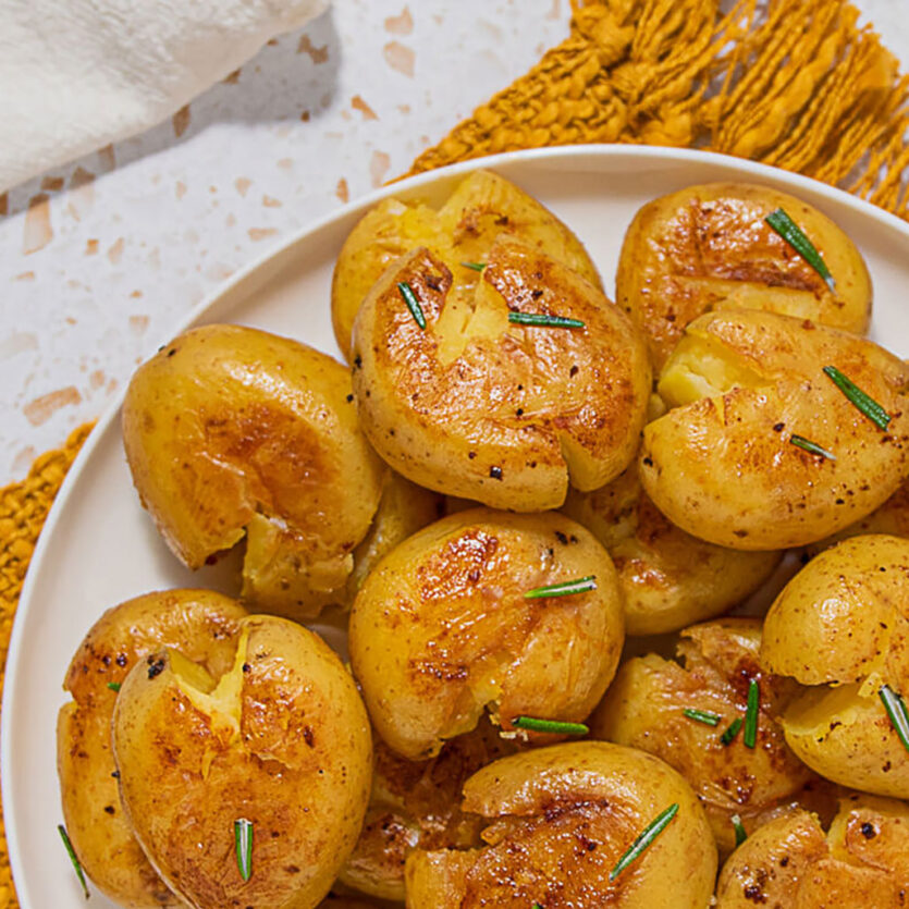 An image of prepared Smashed Potatoes made with Yukon Gold potatoes, Pacific Foods® Organic Chicken Stock, rosemary and olive oil.
