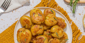 An image of prepared Smashed Potatoes made with Yukon Gold potatoes, Pacific Foods® Organic Chicken Stock, rosemary and olive oil.