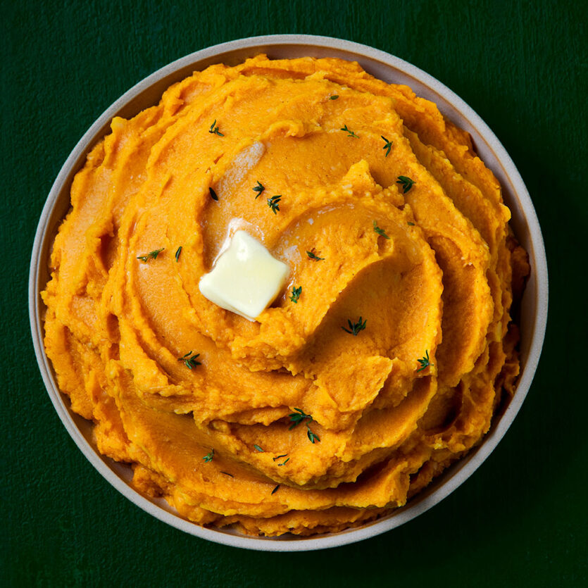 An image of prepared Mashed Root Vegetables made with yams, parsnips, Pacific Foods® Organic Creamy Butternut Squash Soup and butter.