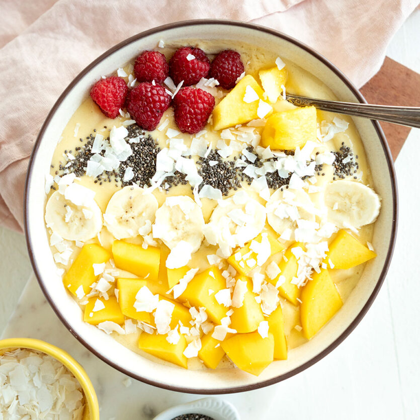 An image of prepared Pina Colada Smoothie Bowl made with Pacific Foods® Organic Coconut Unsweetened Original Beverage, banana, mango, raspberries and coconut.