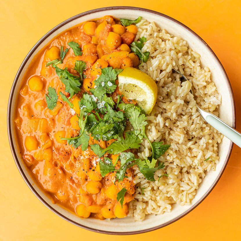 An image of prepared Slow-Cooker Butternut Chickpea Curry made with curry powder, crushed tomatoes, chickpeas, Pacific Foods® Organic Creamy Butternut Squash Soup, brown rice, cilantro and lemon.