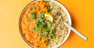 An image of prepared Slow Cooker Butternut Chickpea Curry made with curry powder, crushed tomatoes, chickpeas, Pacific Foods® Organic Creamy Butternut Squash Soup, brown rice, cilantro and lemon.
