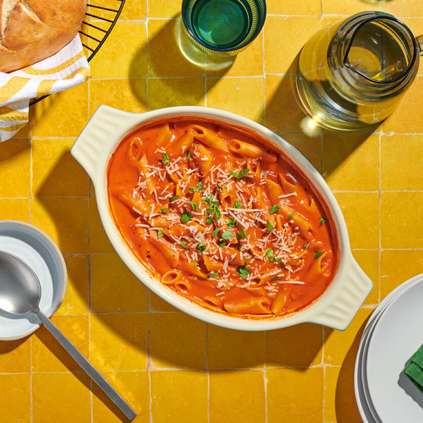An image of prepared One Pan Roasted Red Pepper Penne Pasta Bake made with Pacific Foods® Organic Roasted Red Pepper & Tomato Soup, Pacific Foods® Organic Vegetable Broth, penne pasta and crushed red pepper.