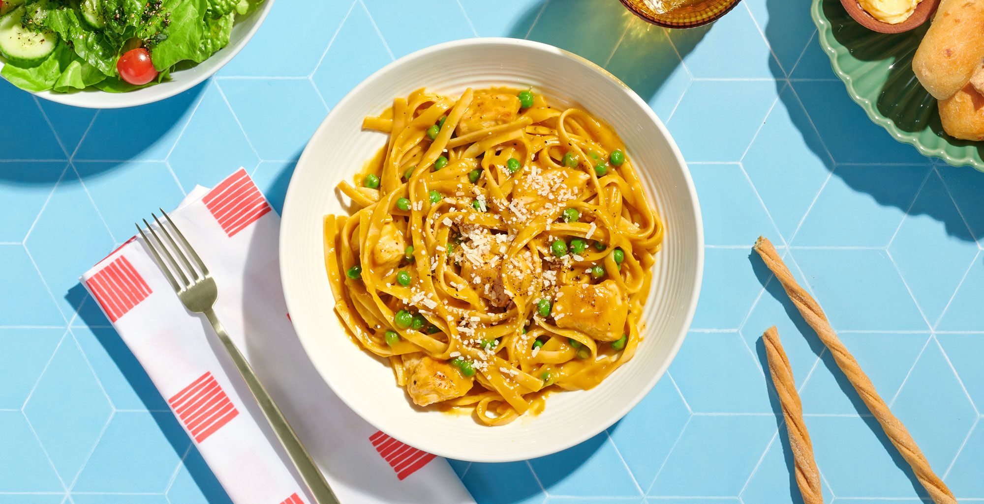 An image of prepared One-Pot Butternut Squash Alfredo with Chicken & Peas made with chicken, Pacific Foods® Organic Creamy Butternut Squash Soup, Pacific Foods® Organic Free Range Chicken Broth, fettuccine, green peas and Parmesan.